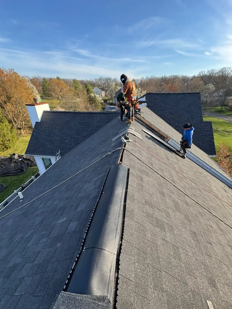 Roofing crew installing shingles on a New Jersey home