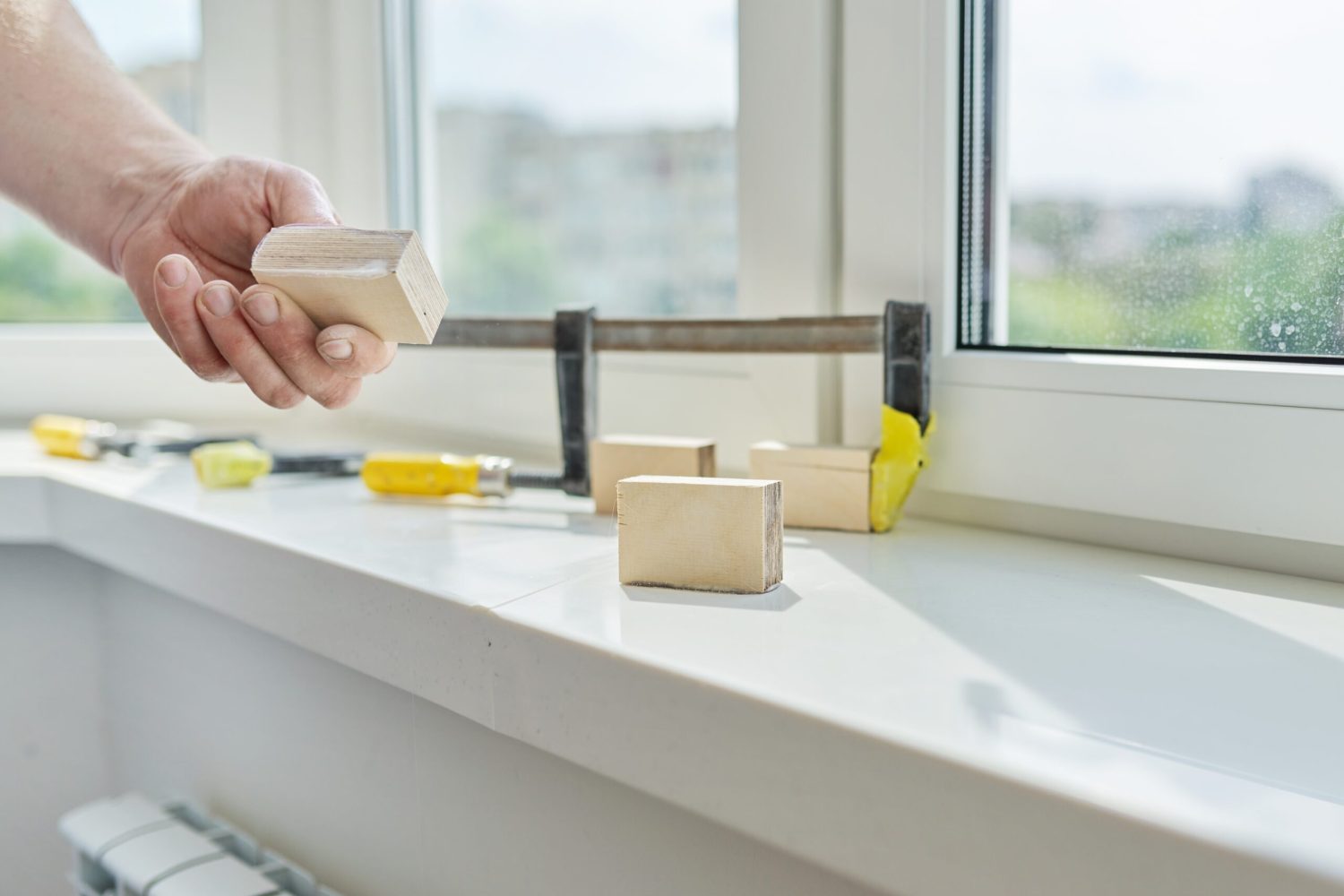 Artificial stone window sill, installation, technological process. Repair, construction of house, apartment. Close up of worker's hand with tools and parts